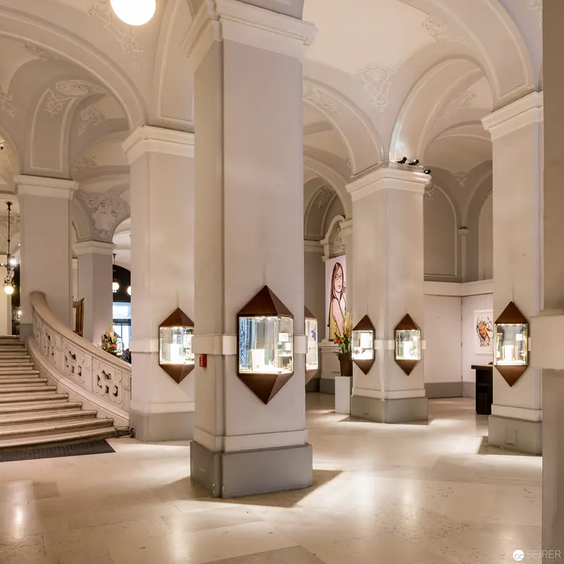 Grand Museum Interior with Illuminated Display Cases and Architectural Arches