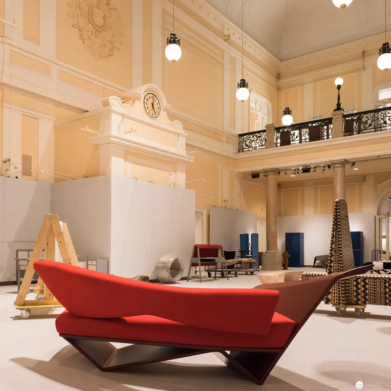 Red Modernist Seating Sculpture in Ornate Neoclassical Exhibition Space