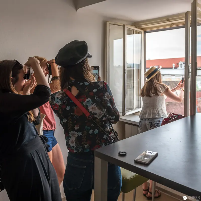 Women Observing Urban Landscape through Window in Intimate Interior Setting