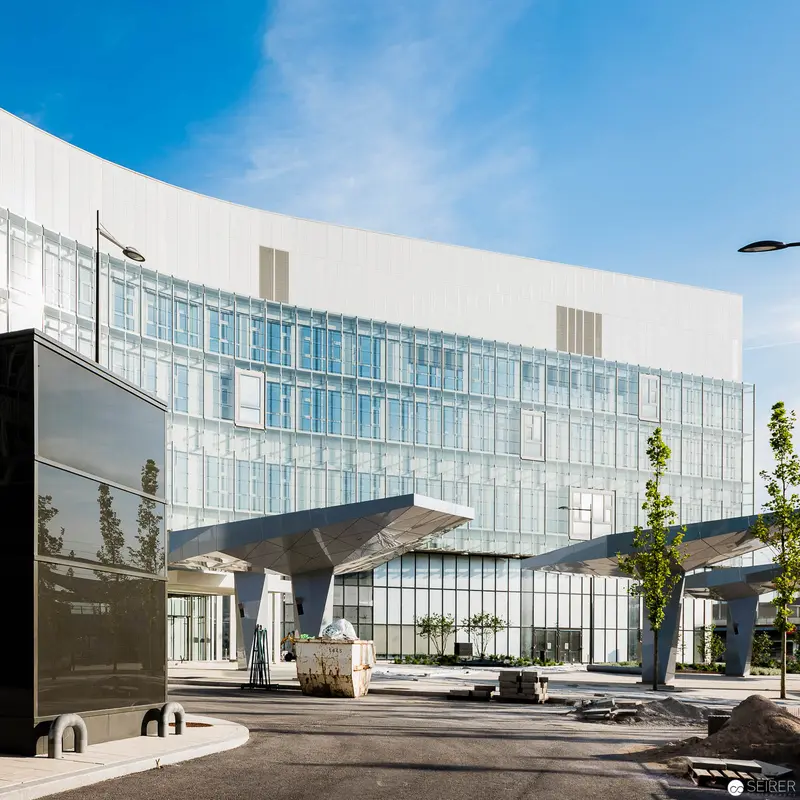 Modern Glass Hospital Architecture at Wien Nord with Distinctive Cantilevered Entrance