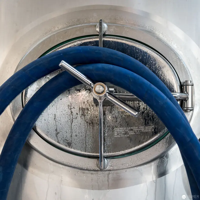 Industrial Precision: Circular Valve with Blue Hydraulic Hose
