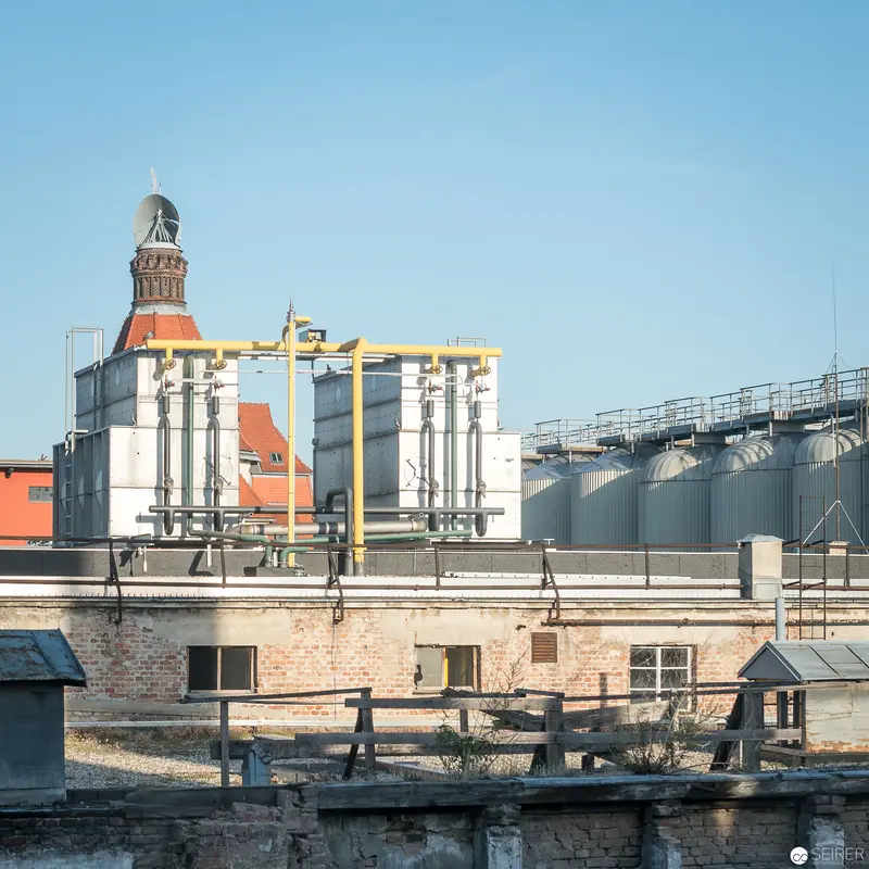 Industrial Architectural Landscape with Historic Tower and Modern Storage Tanks
