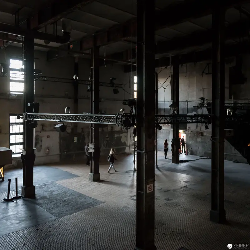Industrial Interior with Silhouetted Figures in Atmospheric Warehouse Space