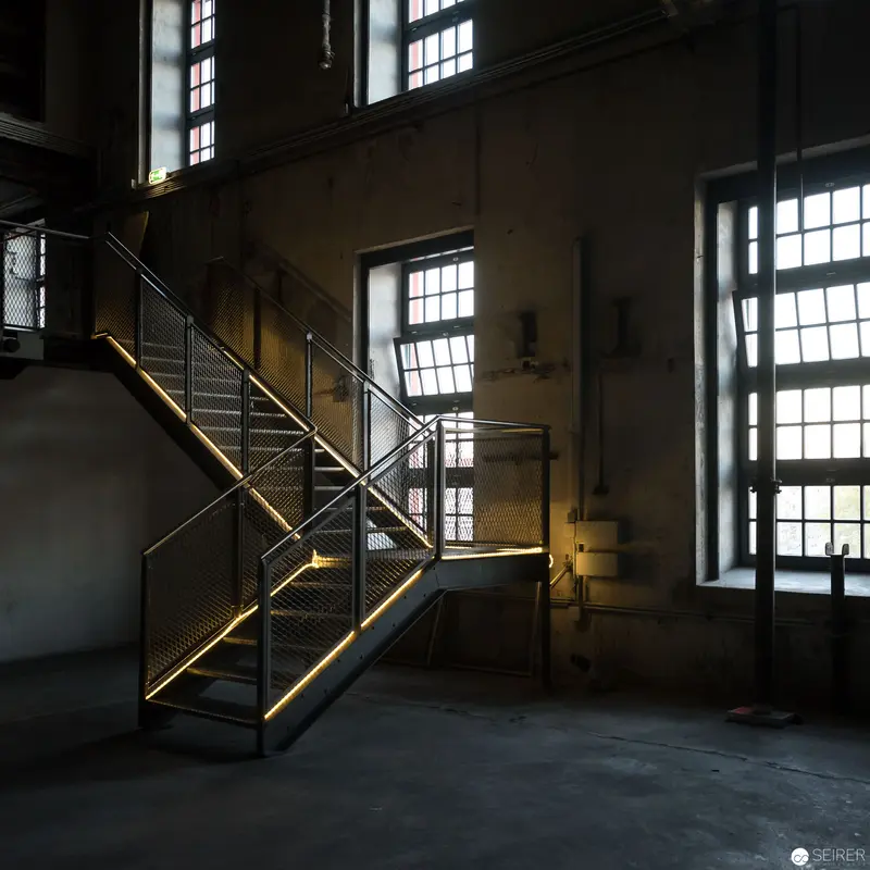Industrial Interior with Illuminated Metal Staircase in Abandoned Factory Space
