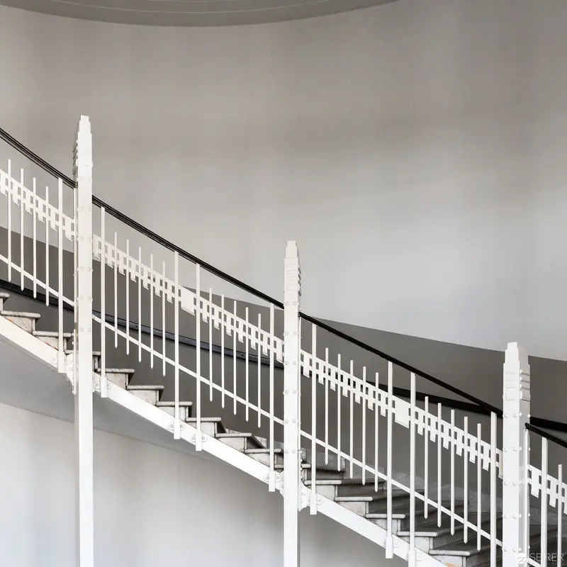 White Architectural Staircase with Geometric Railing Against Neutral Wall