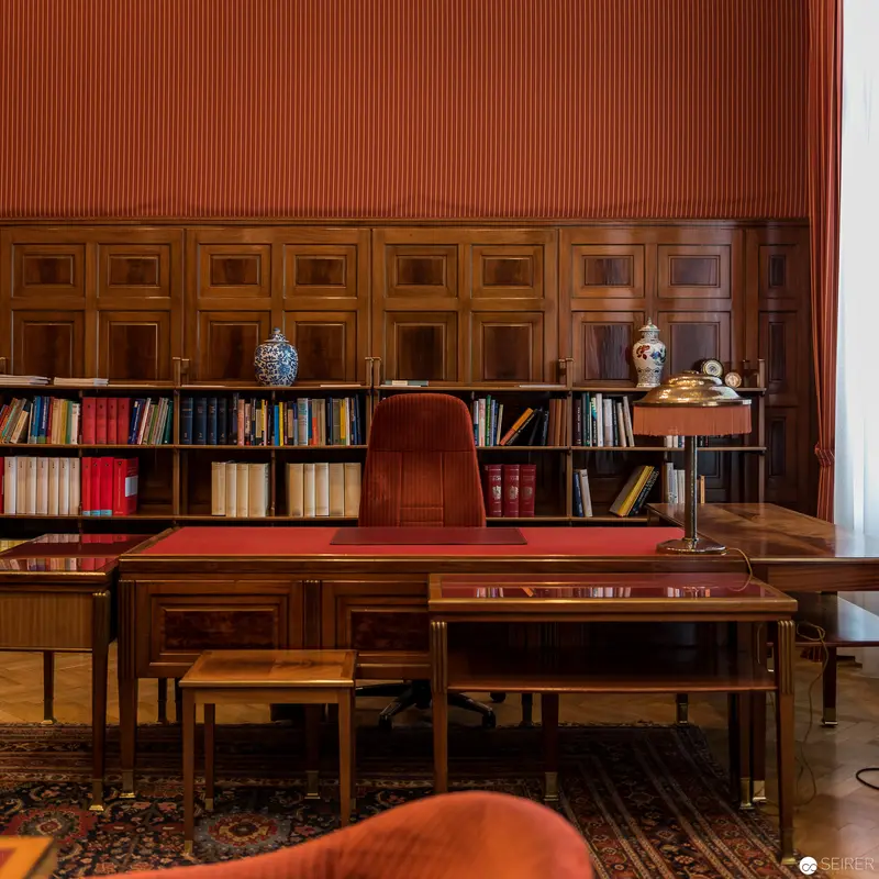 Classical Study with Wooden Paneling, Antique Bookshelf, and Ornate Writing Desk