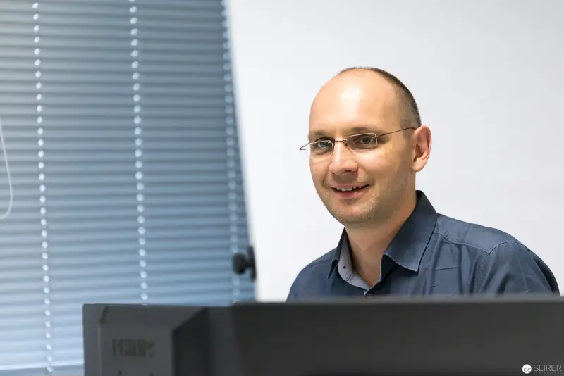 Microsoft User Group Meeting: Professional Smiling at Computer Workstation