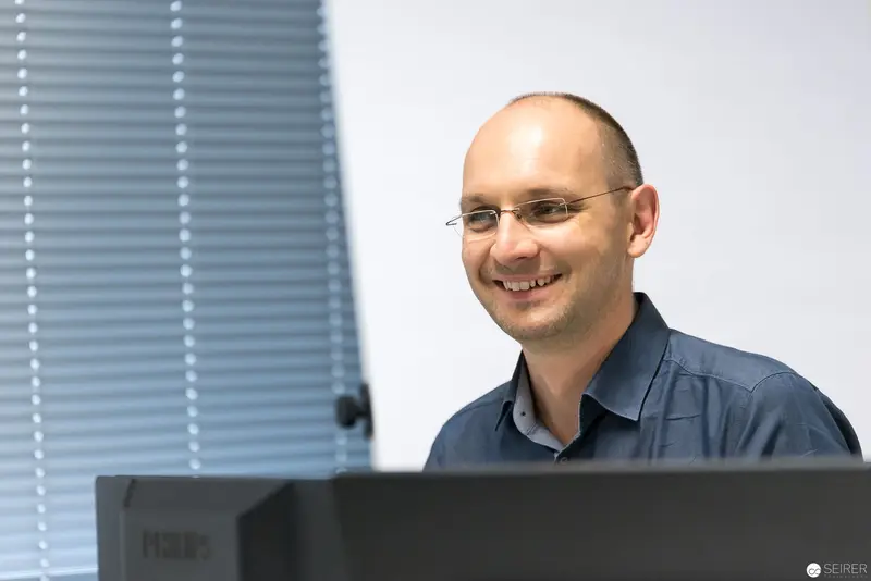 Smiling Professional at Microsoft User Group Meeting Workstation