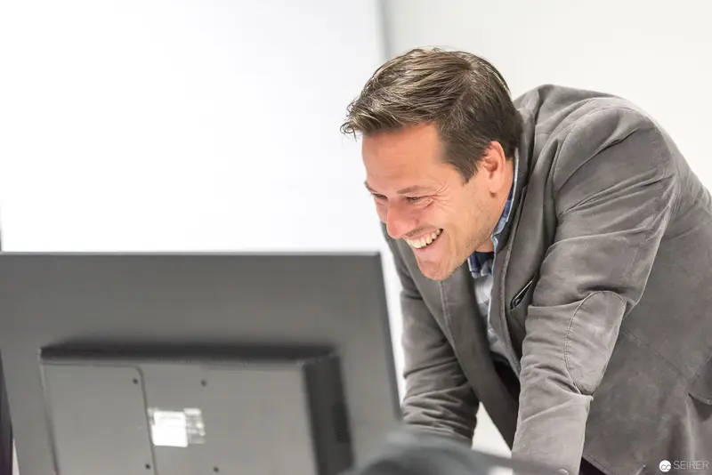 Microsoft User Group Meeting: Professional Smiling at Computer Workstation