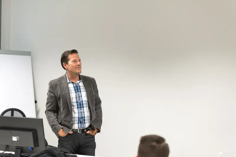 Microsoft User Group Meeting: Professional Presenter in Plaid Shirt and Gray Blazer