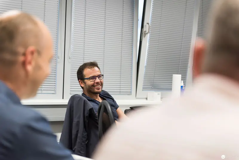 Microsoft User Group Meeting: Engaged Participant Smiling During Discussion