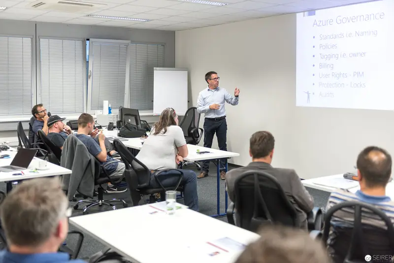 Microsoft User Group Meeting: Presenter Discussing Azure Governance in Corporate Training Room