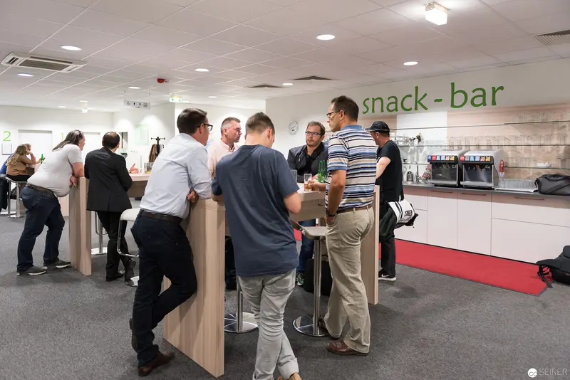 Microsoft User Group Meeting: Colleagues Convene at Sleek Snack-Bar Environment