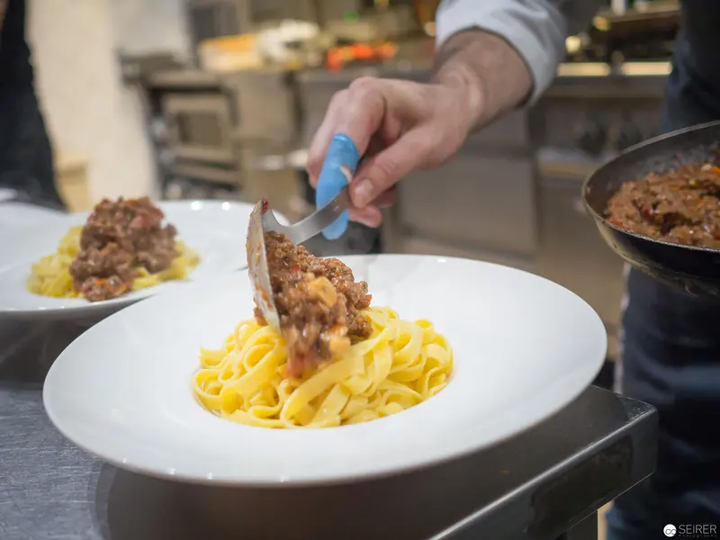 Chef Plating Bolognese Pasta at Benjaminis Restaurant in Vienna