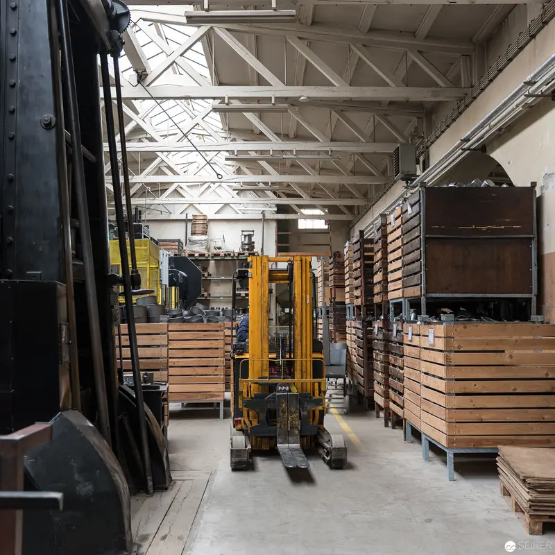 Yellow Forklift Navigating Wooden Crate Storage at Riess Emaille Manufaktur