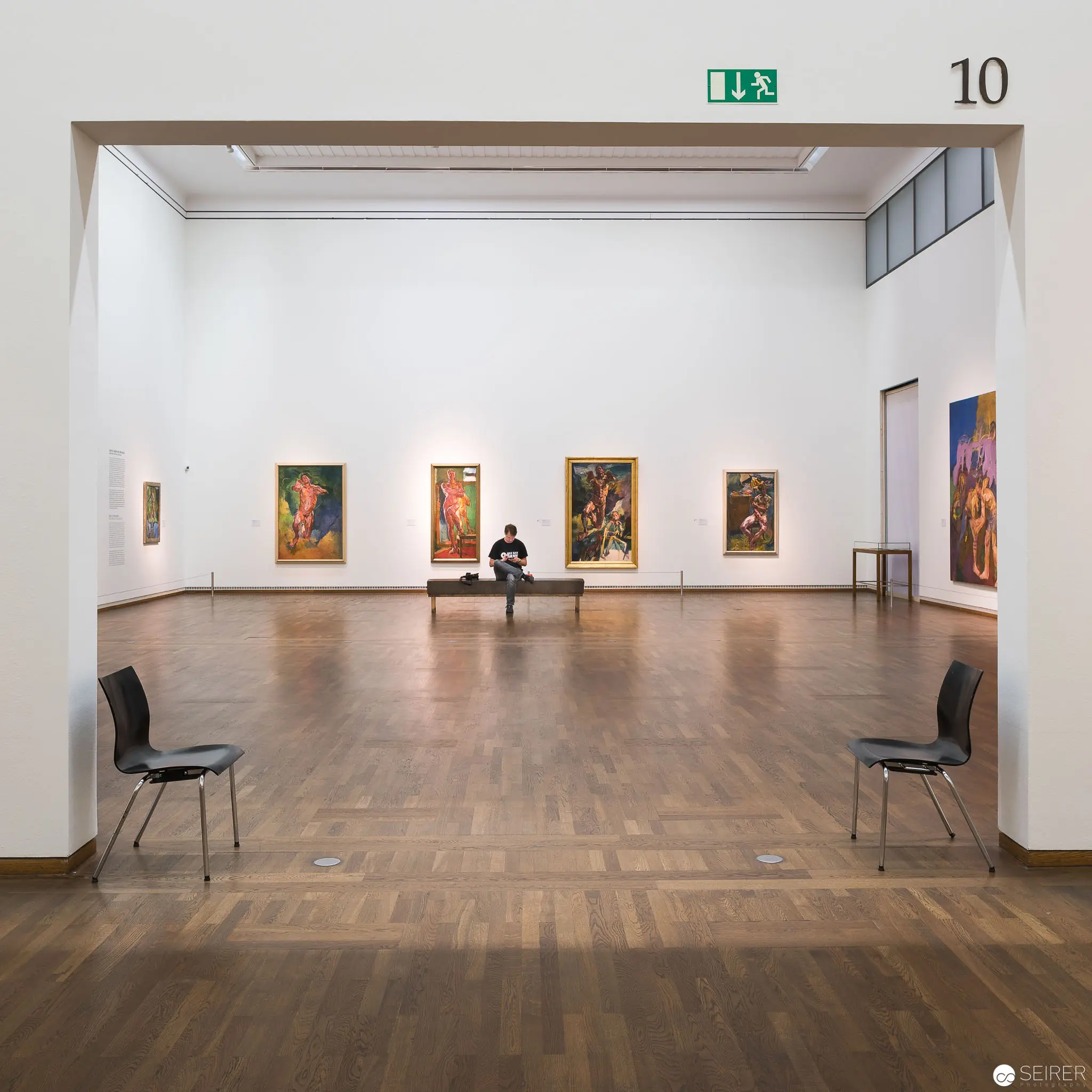 Contemplative Gallery Space with Modernist Paintings and Solitary Viewer