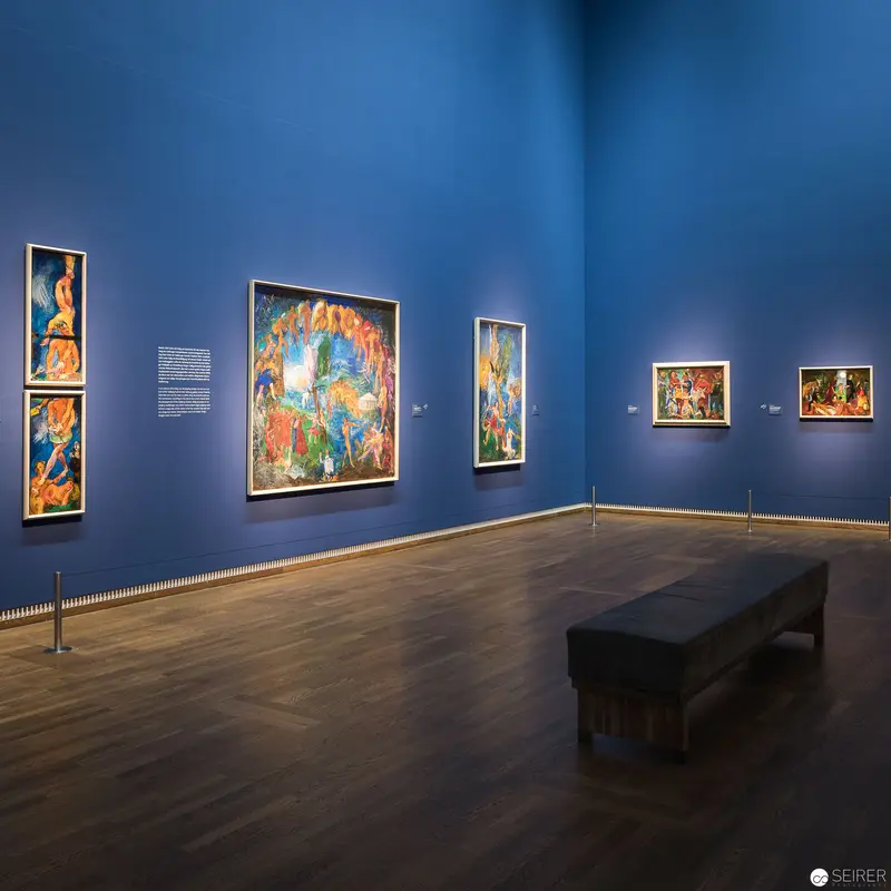 Gallery Interior with Vibrant Artworks Displayed on Deep Blue Walls