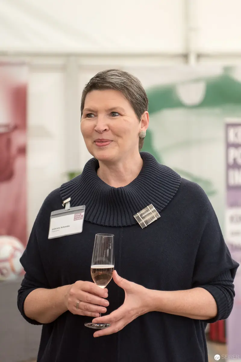 Professional Woman in Dark Sweater Holding Champagne at Corporate Event