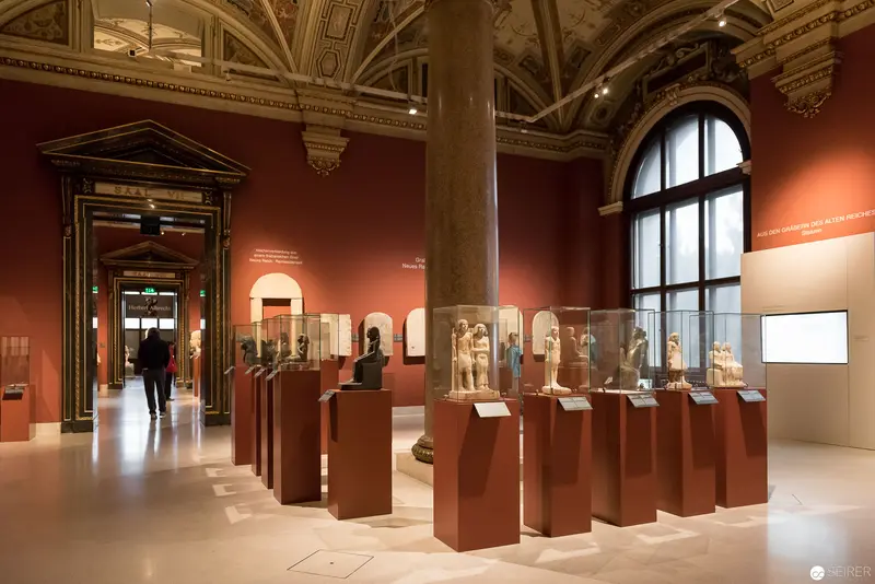 Museum Exhibition of Classical Sculptures in Ornate Architectural Gallery Space