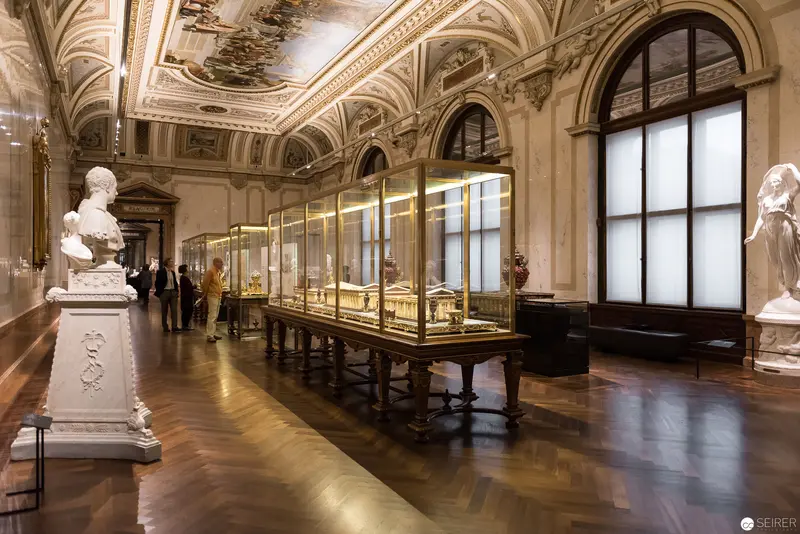 Ornate Museum Gallery with Illuminated Display Cases and Sculptural Busts