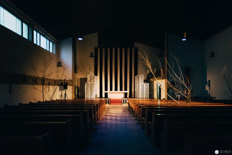 Architectural Interior of Minimalist Chapel with Dramatic Lighting and Bare Branches
