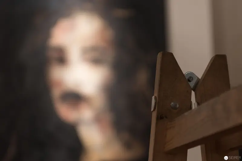 Blurred Figure Near Wooden Easel in Soft-Focus Photographic Study