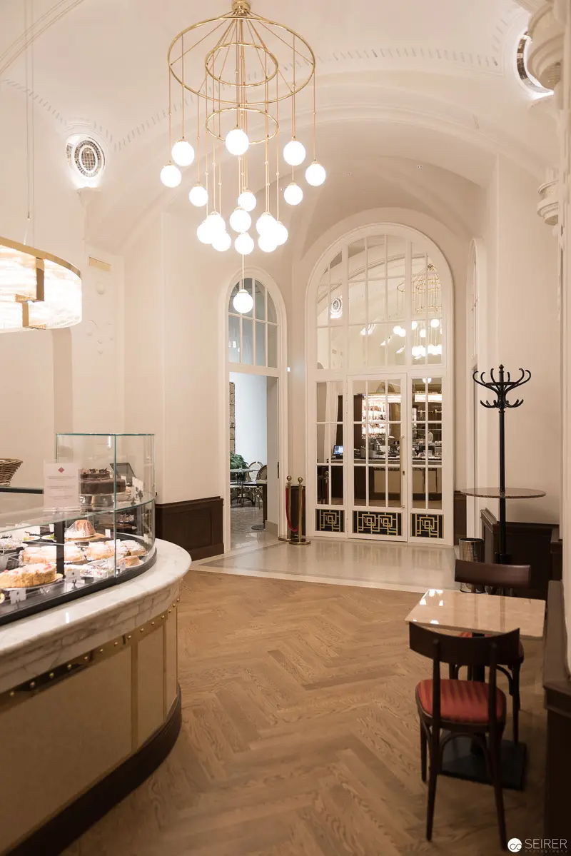 Elegant Viennese Café Interior with Gold Chandelier and Herringbone Parquet