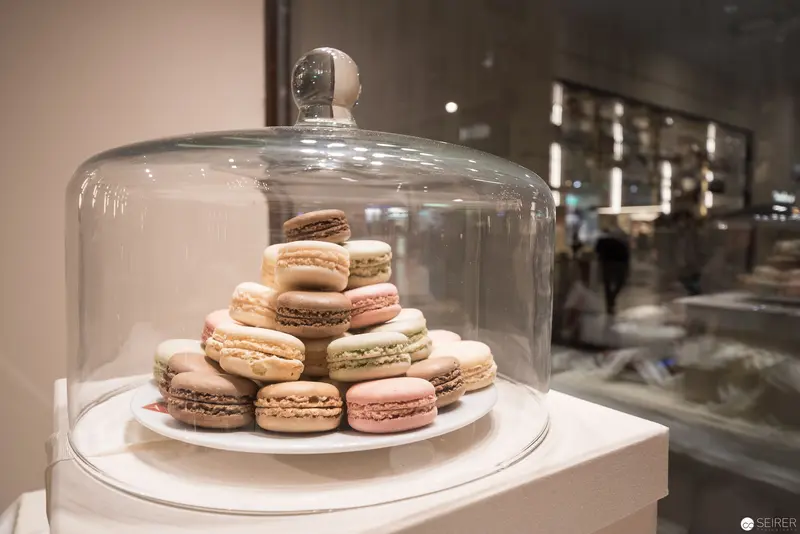 French Patisserie Still Life: Macarons Arranged Pyramidally Under Glass Dome