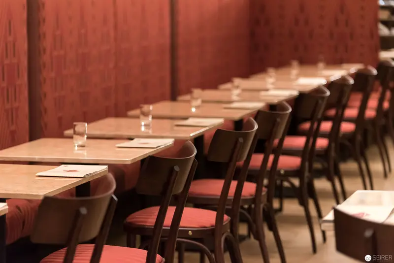 Intimate Restaurant Interior with Wooden Tables and Red Upholstered Chairs