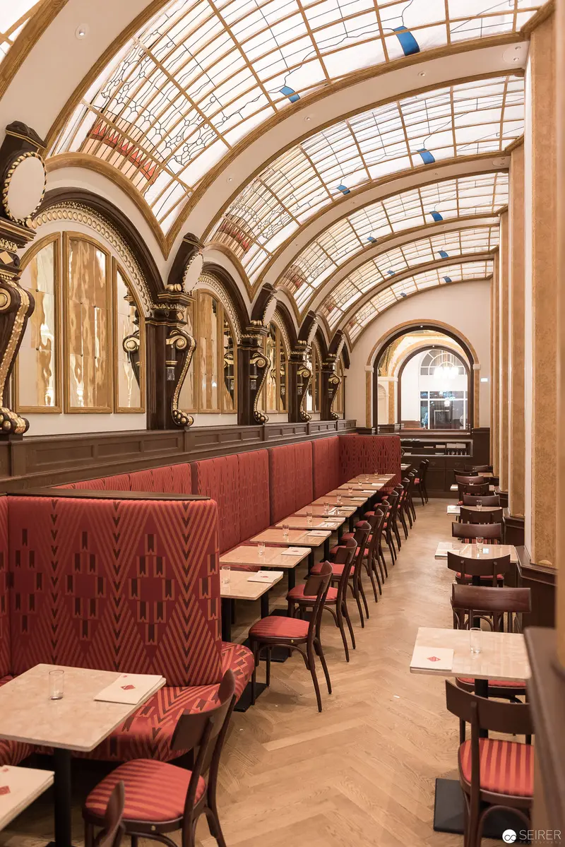 Ornate Viennese Café Interior with Arched Glass Ceiling and Red Upholstery