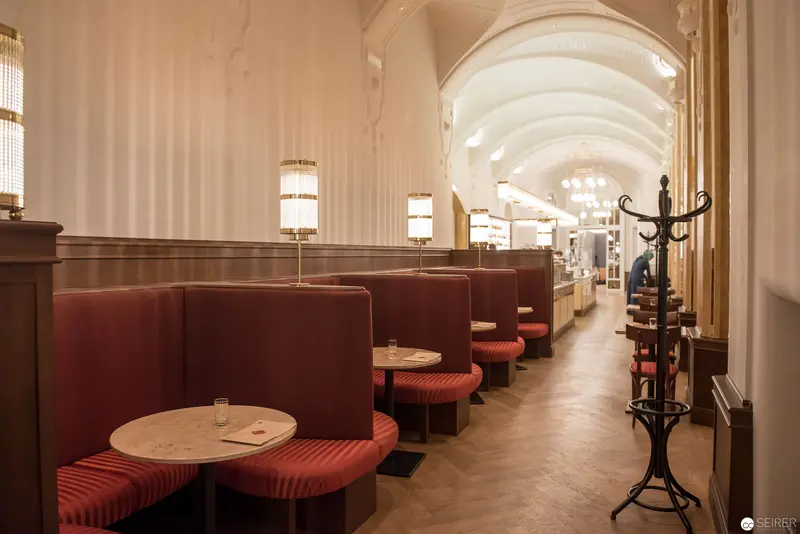 Elegant Art Nouveau Café Interior with Curved Arched Ceiling and Burgundy Booths