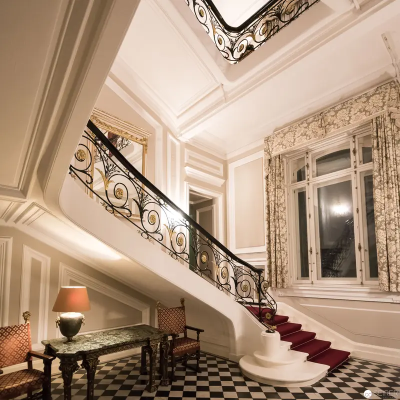 Ornate Viennese Interior with Sweeping Staircase and Decorative Wrought-Iron Balustrade
