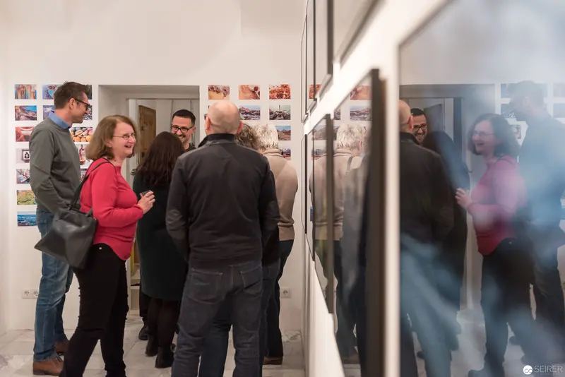 Wolf Hoffmann Vernissage: Gallery Visitors Engage with Photographic Exhibition Displays