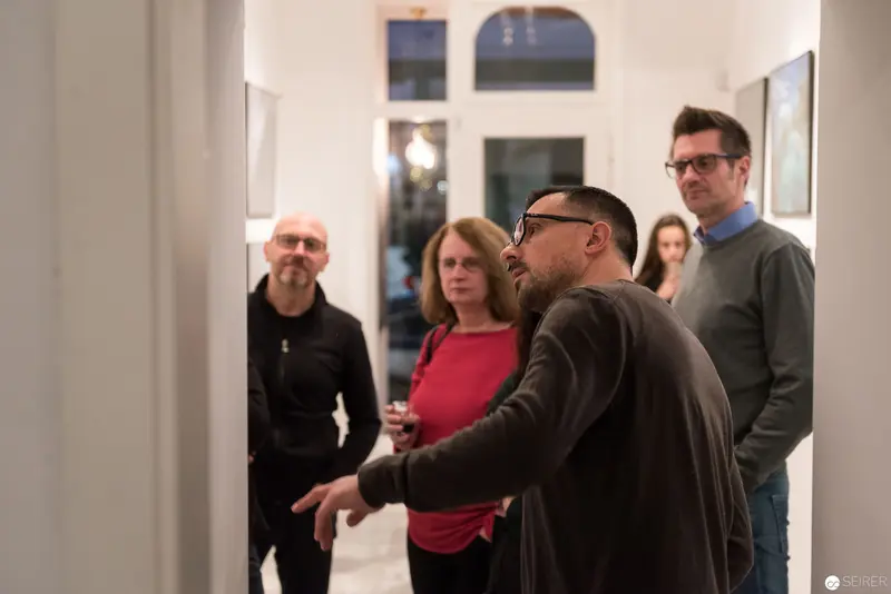 Wolf Hoffmann Vernissage: Gallery Attendees in Contemplative Dialogue