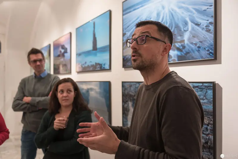 Wolf Hoffmann's Photographic Exhibition: Curator Discussing Visual Narratives at Gallery Opening