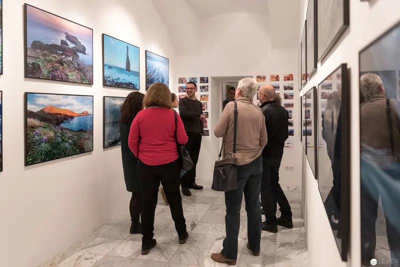 Wolf Hoffmann Vernissage: Visitors Examining Landscape Photographs in Gallery Setting