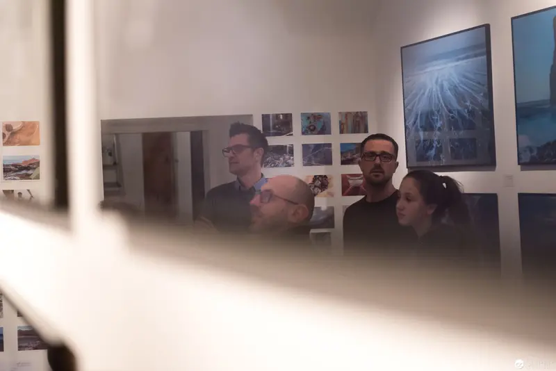 Wolf Hoffmann Vernissage: Gallery Visitors Observing Photographic Exhibition Space