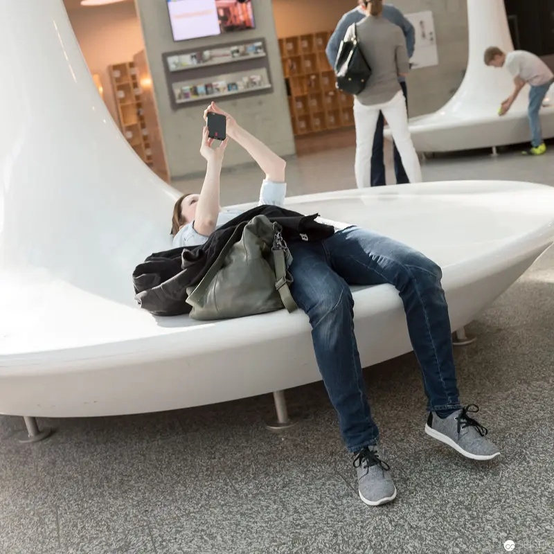 Contemporary Spatial Interaction: Reclining Figure with Mobile Device in Minimalist Interior