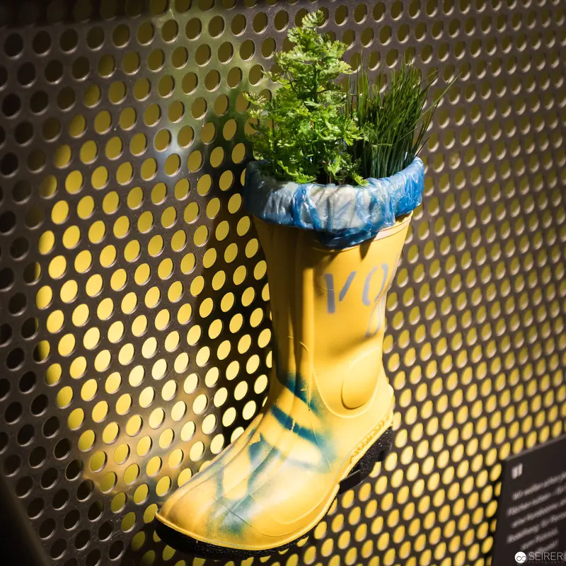 Ceramic Rain Boot Transformed into Botanical Planter Against Perforated Background