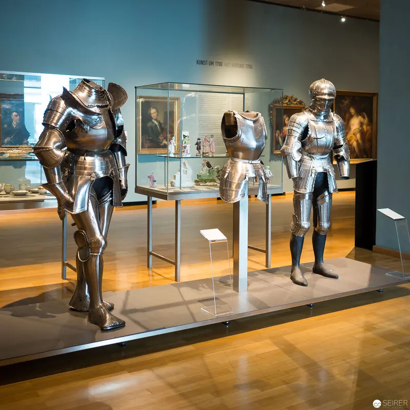 Medieval Knight Armor Display at Museum Exhibition with Historical Portraits