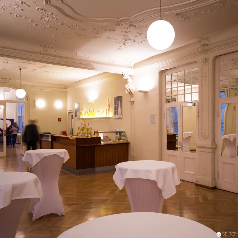 Ornate Interior of Ronacher Theater Foyer with White-Draped Tables