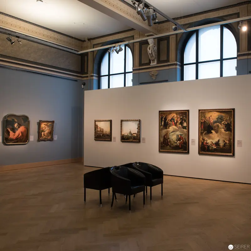 Gallery Installation of Classical Paintings with Arched Windows and Modern Seating