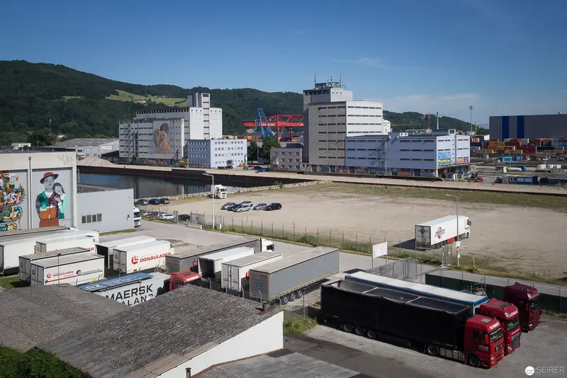 Urban Industrial Landscape with Shipping Containers and Freight Vehicles in Mountain Setting