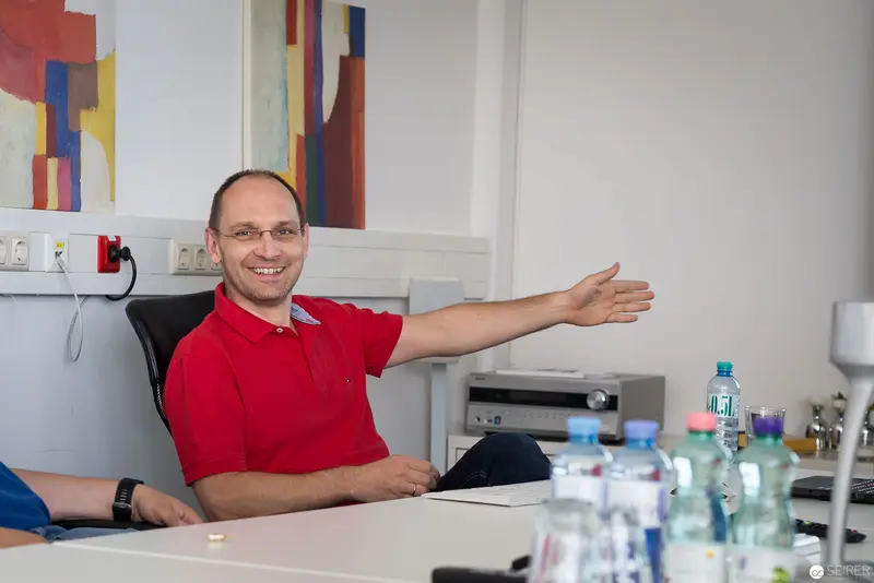Experts Live Usergroup Meeting in Linz: Engaged Participant in Red Polo Shirt