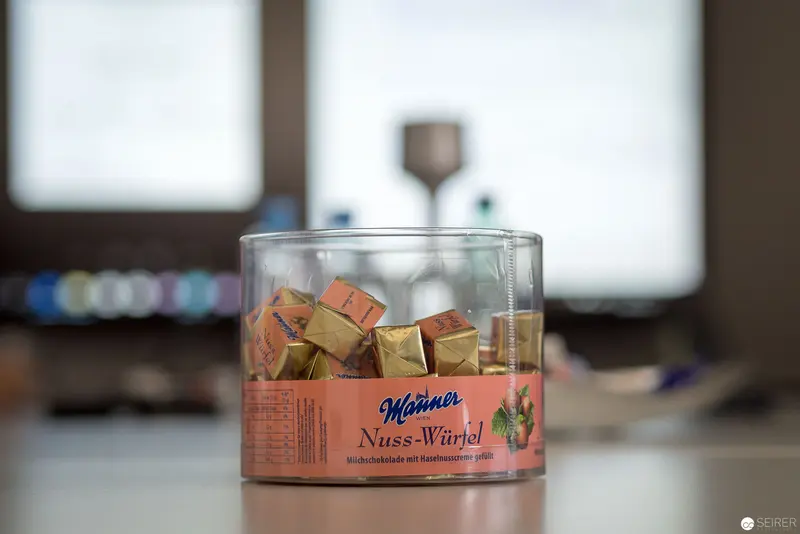 Manner Nuss-Würfel Chocolate Cubes in Glass Container on Blurred Background
