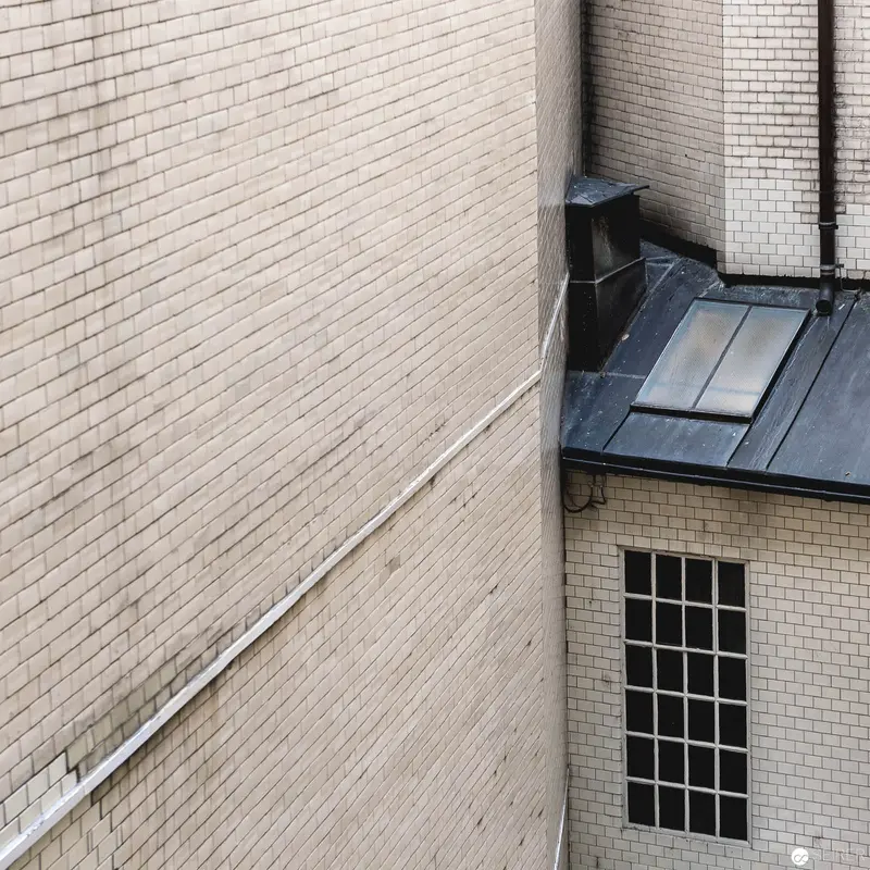 Architectural Geometry: Brick Wall Intersection with Metal Roof and Industrial Window