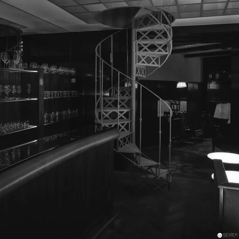 Spiral Staircase in Monochrome Interior with Glassware and Ambient Lighting