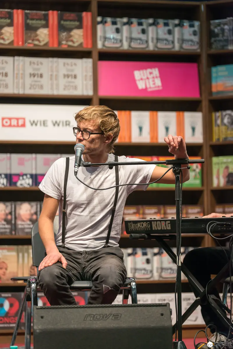 Musician Performing at Bookstore Event with Keyboard and Microphone