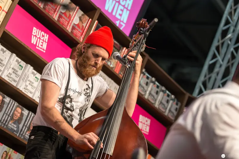 Upright Bassist in Red Beanie Performing at Buch Wien Literary Event