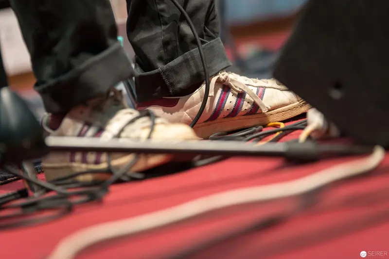 Striped Sneakers on Red-Toned Performance Stage Floor